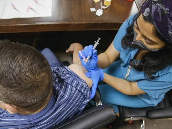 Maya Sarihan, MD, then a College of Medicine – Tucson 4th year medical student, administers a COVID-19 vaccine to an agricultural laborer at the Consulate of Mexico in Douglas, Arizona, as part of a MOVE UP clinic hosted by UArizona Health Sciences.