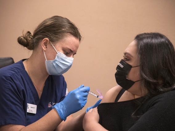 College of Nursing student Valerie Pedersen gives a woman a COVID-19 vaccine at a MOVE UP clinic at the Consulate of Mexico in Douglas hosted by the UArizona Health Sciences in partnership with the Cochise County Health Department.
