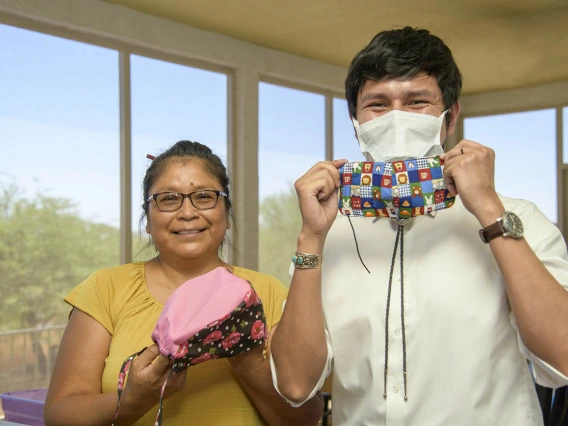 Navajo seamstress Theresa Hatathlie-Delmar and College of Medicine – Tucson student Aaron Bia pose with masks made from donated material.