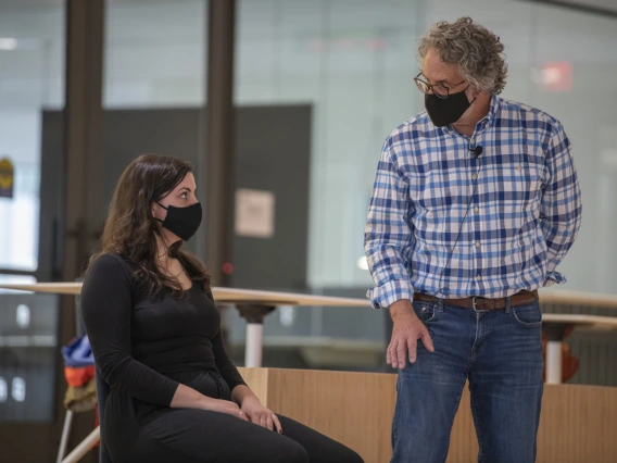 Jennie Greb listens as Andrew Belser explains how gravity pushes through her head down to her hips while in a seated position. Greb is one of the few in-person participants of the “Aging and the Arts” series inside the Forum in the Health Sciences Innovation Building.