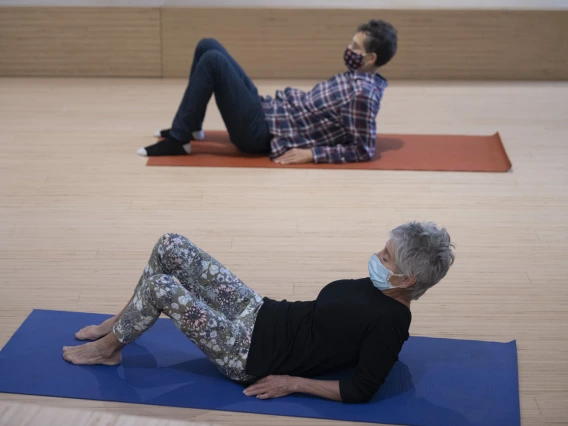 Ron Bachorski and Virginia Belser sit up while practicing a movement exercise.