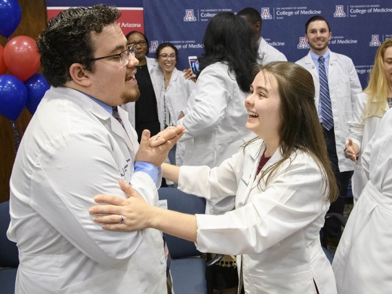 Primary Care Physician scholarship recipient China Rae Newman, right, congratulates fellow scholarship recipient Raymond Larez, MPH, after his speech at the Tucson scholarship reception. 