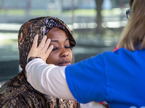 A Street Medicine Phoenix volunteer examines a woman seeking medical attention for a bump on her eye, which turned out to be a stye.