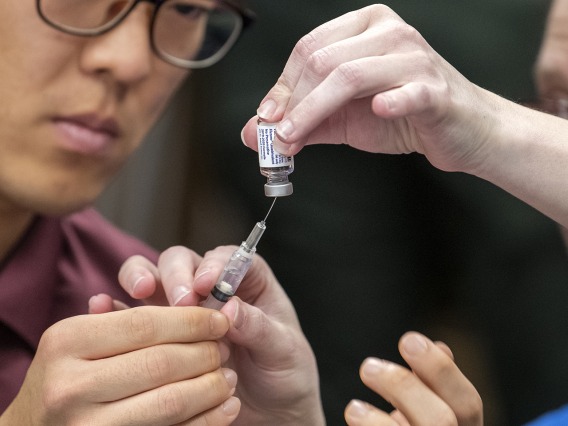 A Street Medicine Phoenix student volunteer prepares to administer a flu vaccine.