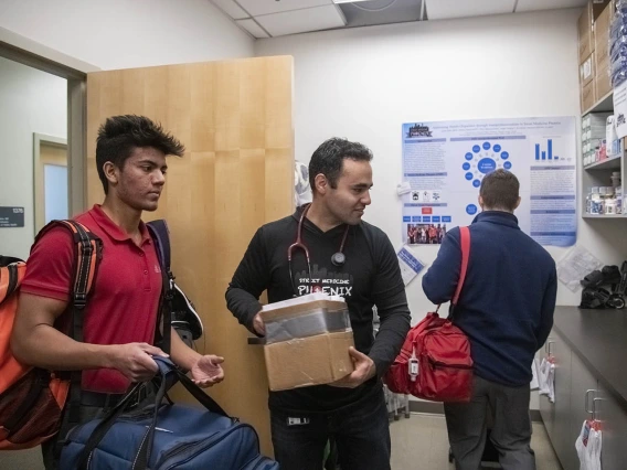 Student volunteer Eashan Das, left, co-founder Jeffery Hanna, center, and co-founder Justin Zeien, right, put away supplies in the Street Medicine Phoenix storage area on College of Medicine – Phoenix campus after the Grace Lutheran Church street run.