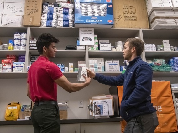 Student volunteer Eashan Das and co-founder Justin Zeien grab Street Medicine Phoenix supplies from the on-campus storage area for the February 23, 2020 street run at Grace Lutheran Church.