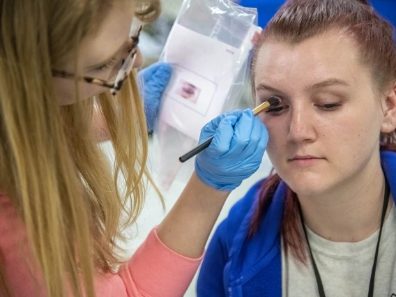 Sadie Keesler, an undergraduate at the University of Arizona College of Science and ASTEC volunteer, spent one morning of her Spring Break applying makeup to TPD volunteers roleplaying injured travelers. Here, Kessler creates a black eye on Tylinn Smith.