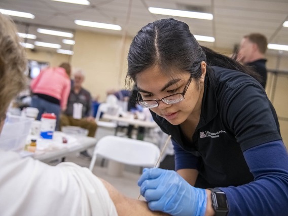 Merryl Lopido, simulation operations specialist for ASTEC, places fake skin on a woman to simulate a wound sustained during a flight. In this scenario, a drone landed on an airplane’s wing and exploded, injuring several passengers and forcing the plane to land.