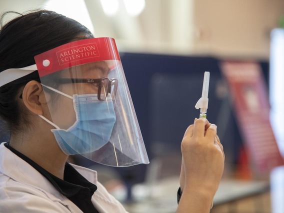 Fourth-year College of Pharmacy student Lisa Le expels air bubbles out of a flu vaccine before administering it to a fellow student as part of a student flu shot clinic in October.