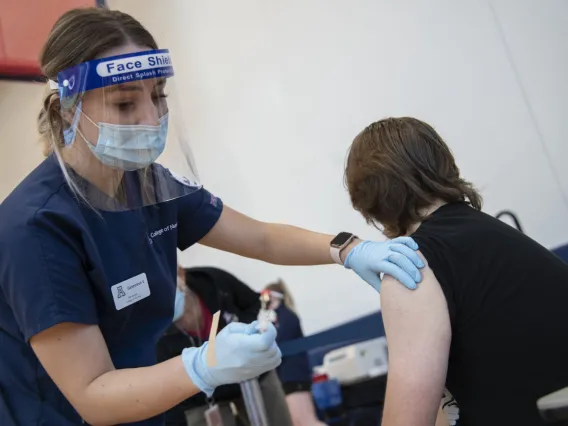 Nursing student Genevieve Veneziale disinfects a student’s arm before administering a flu shot inside NorthREC. Veneziale says she saw several first-time flu-shot recipients at the clinic.