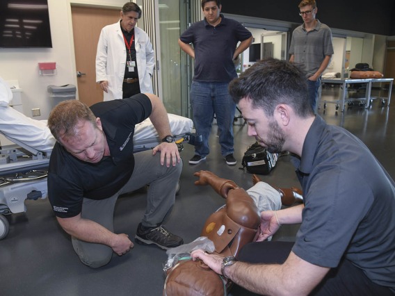 Using lifelike manikins, ASTEC personnel train staff from a local drug rehab facility to treat overdose with naloxone. ASTEC Executive Director Allan Hamilton, MD, FACS, observes from the back left.