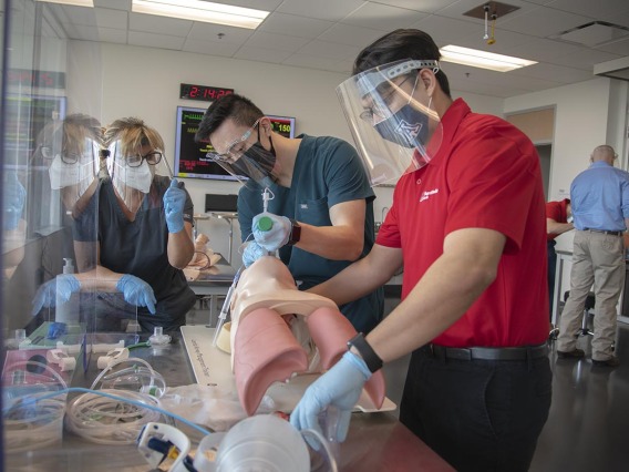 Second-year College of Medicine – Tucson students Paul Nguyen, left, and Arturo Hernandez practice intubation in the ASTEC lab Nov. 18. Instructor Deana Smith, BS, BSN, RN, is an ASTEC simulation education specialist.