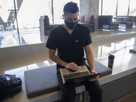 First year College of Medicine – Tucson student Charles Andrew Jauregui checks into Daily Wellness Screening on his laptop before heading to a class. The wellness checks must be completed using the Wildcat WellCheck screening tool, which allows employees and students to self-screen for symptoms before they arrive on campus.