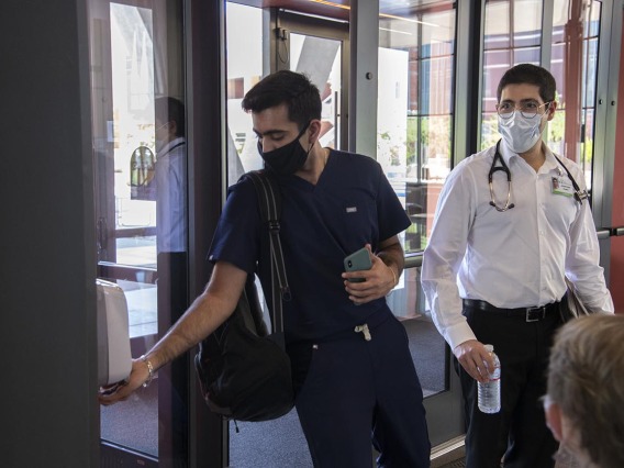 First year College of Medicine – Tucson student Yasi Suri, left, uses hand sanitizer before he and fellow first year student Jonathan Yasmeh head to a class in the Health Science Innovation Building.