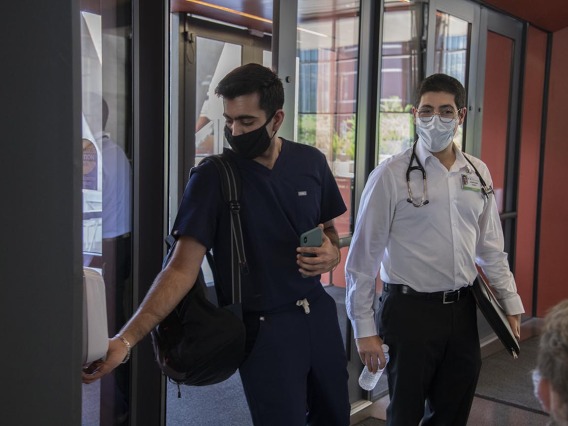 First year College of Medicine – Tucson student Yasi Suri, left, puts sanitizer on his hands before he and fellow first year student Jonathan Yasmeh  head to a class in the Health Science Innovation Building.