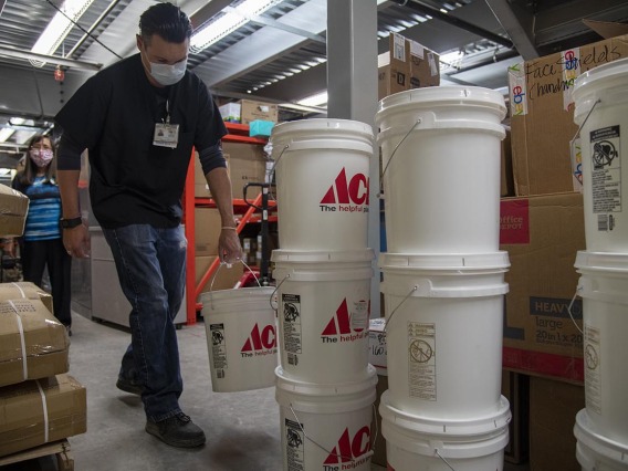 Josh Cliffords carries buckets of sanitizer into a warehouse for Tuba City Regional Health Care. The sanitizer will be distributed to the health center and the community.