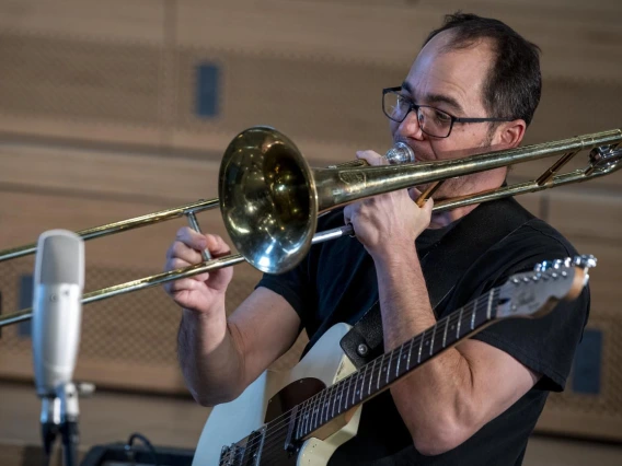 Two-Door Hatchback’s Marco Rosano plays a trombone while filming for The Tucson Studio. Rosano also plays the guitar for the band. 