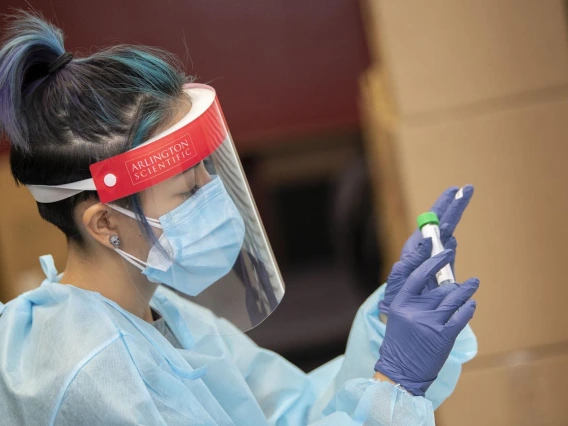 Registered nurse Shannon Espinosa puts a label on a tube for an antigen test at the University of Arizona Phoenix Biomedical Campus.