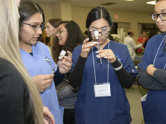 High school students learning about career options in health care visit the nursing booth.