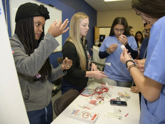 High school students learning about career options in health care visit the nursing booth.