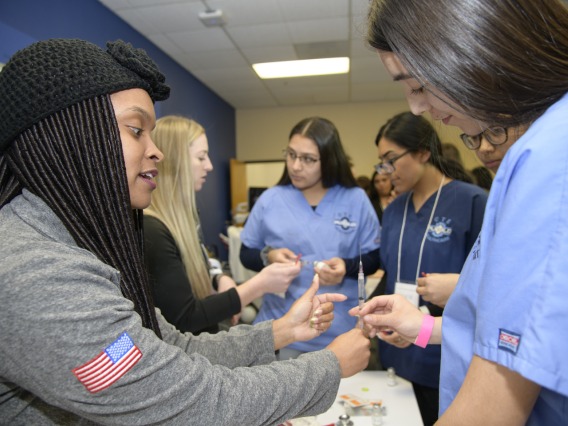 High school students learning about career options in health care visit the nursing booth.
