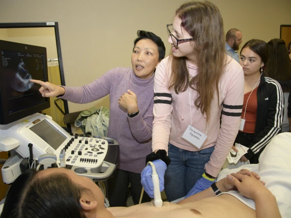 A high school student practices performing an ultrasound on a human heart.