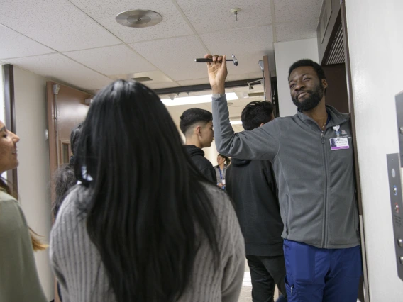 A UArizona College of Medicine - Tucson neurology student asks the tour group what they know about the tool in his hand.