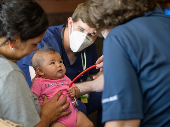 Judith Hunt, MD, and student Jeremy Winkleman win over Anastasia Lopez by letting her be in control of the stethoscope – perhaps she is a medical student in the making. 