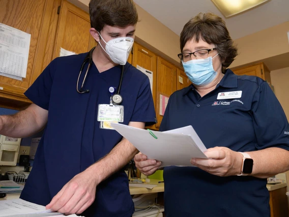 Judith Hunt, MD, and medical student Jeremy Winkleman review charts. 