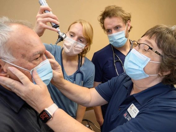 Johnny Waldmann (left) has a mark on his skin examined by resident Lauren Washatka, MD, medical student Colton Cowan and Judith Hunt, MD. 