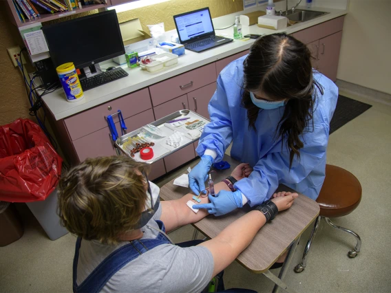 Stephanie Morales draws blood from Emily Jean Krull for a COVID-19 antibody test at the Pima County Health Department in early May.