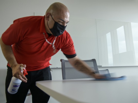 Jose Benitez from University of Arizona Facilities Management cleans a table in the Health Sciences Innovation Building.