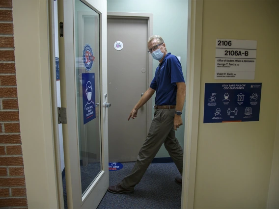 George Fantry, MD, senior associate dean in the College of Medicine – Tucson points to new signage to help people keep appropriate distance.