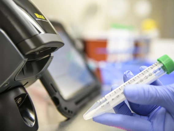 A tube with a name and a code associated with the person who took the antigen test is scanned in the lab.