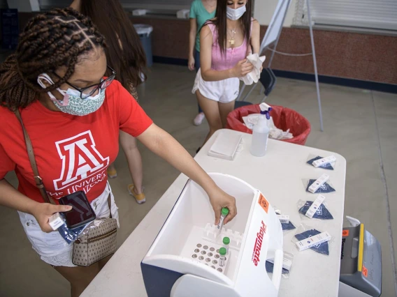 Students deposit their COVID-19 test sample into a cooler for storage at McKale Center in Tucson. 