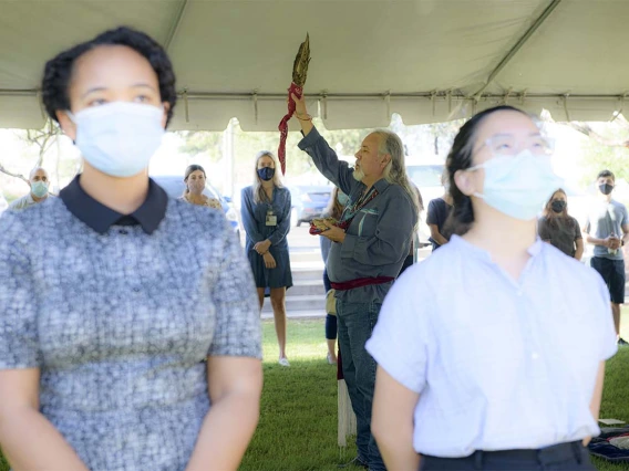 Participants in the Blessing of the Seven Sacred Directions ceremony turn to face west as Dr. Carlos Gonzales leads the blessing. 