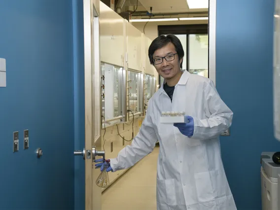 Jun Wang, PhD, walks from a chemistry laboratory into a biology laboratory in the expanded Skaggs research center.