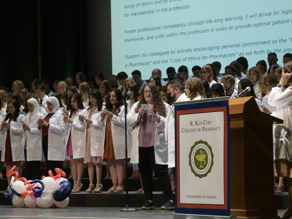 The R. Ken Coit College of Pharmacy class of 2023 recites the pledge of professionalism together after receiving their white coats during a ceremony at Centennial Hall. 