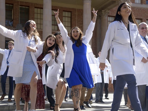 Jennifer Ramirez (center in blue) celebrates with her R. Ken Coit College of Pharmacy 2023 classmates after their white coat ceremony.