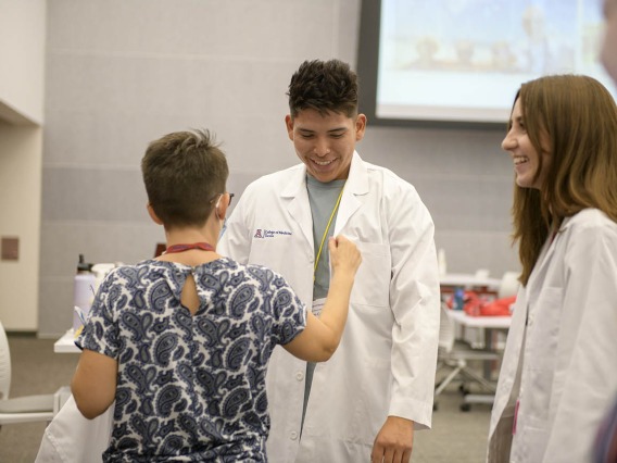UArizona College of Medicine – Tucson first-year medical student Adam Carl gets fitted for his white coat inside the Health Sciences Innovation Building prior to the white coat ceremony. 