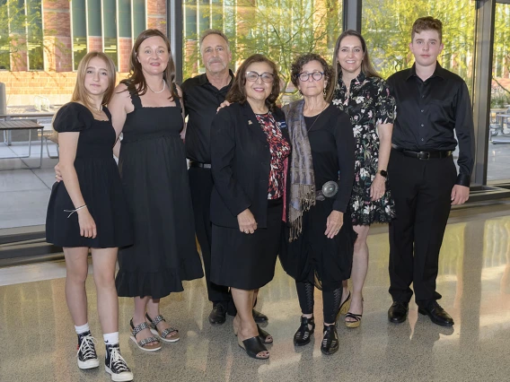 Six members of the Zuckerman family stand with Dr. Iman Hakim. 