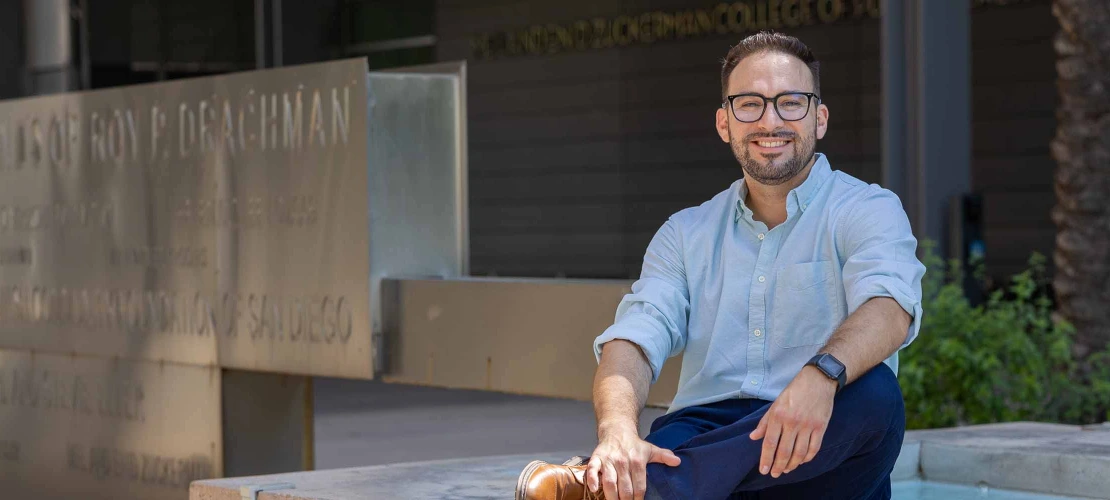 Rogelio Robles-Morales sitting next to a water fountain in front of the Mel and Enid Zuckerman College of Public Health