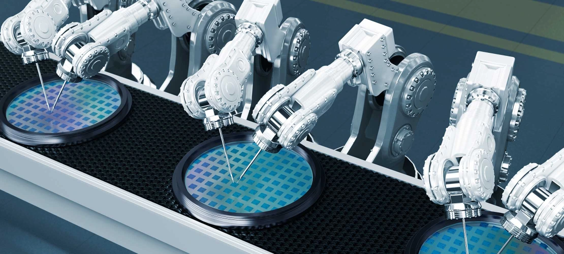Six white robot arms working on blue circles on a semiconductor manufacturing line