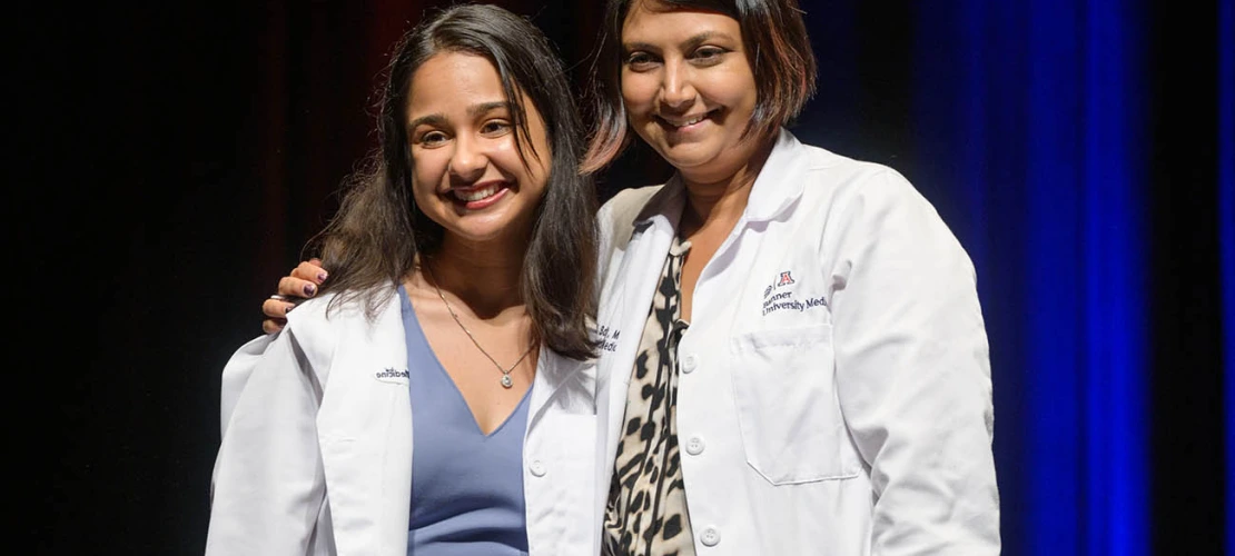 Nandini Sodhi pauses for a photo with Serena Scott, MD, assistant professor of medicine, during the UArizona College of Medicine – Tucson Class of 2026 white coat ceremony.