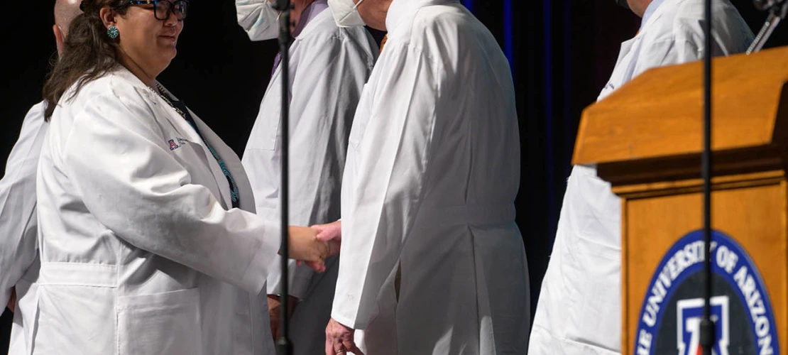 Nicole Bratsch is congratulated by Michael D. Dake, MD, senior vice president for UArizona Health Sciences, after receiving her white coat at the UArizona College of Medicine – Tucson Class of 2026 white coat ceremony.