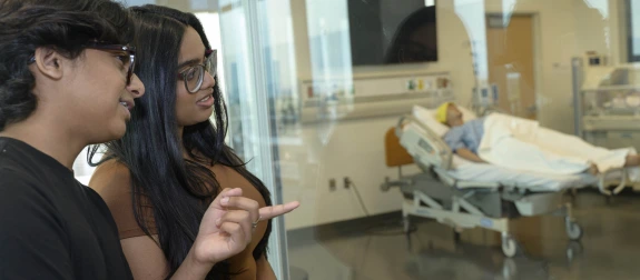 two med students looking at medical simulation lab