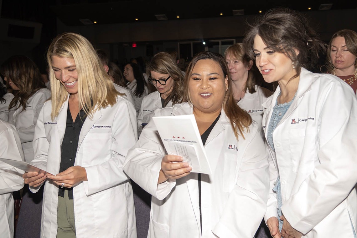 Newly coated Doctor of Nursing Practice students Isabell Diamond Allen, Nicole Renee Escobar and Leah Gawin-Maakestad recite the student oath of responsibility.