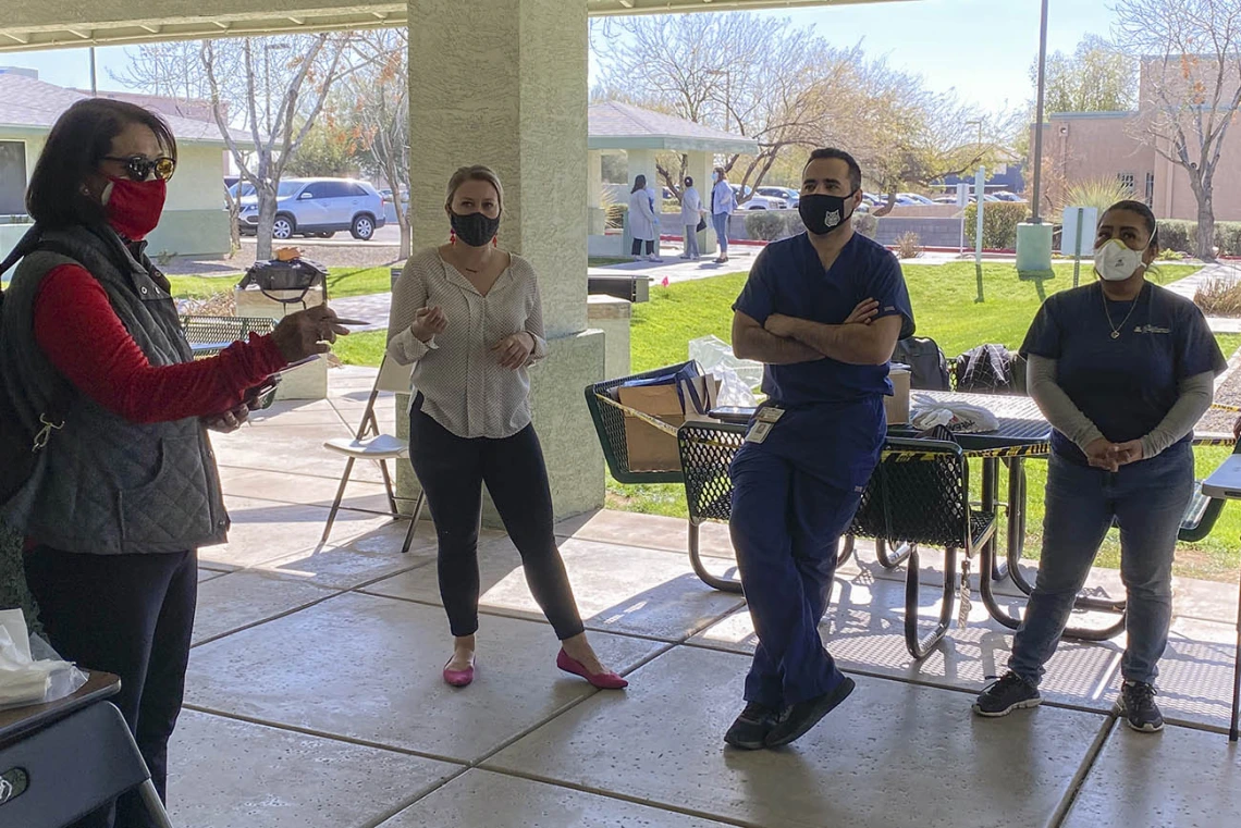 As the COVID-19 vaccine distribution pilot at El Mirage Senior Village wraps up for the day, Dr. Cecilia Rosales of the College of Public Health leads a discussion with her team to learn what worked and what could be improved upon.