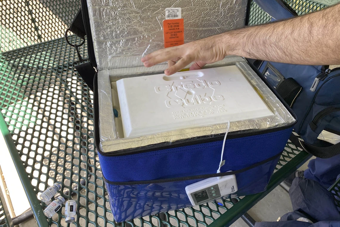 Moderna’s COVID-19 vaccine vials are stored in a portable cooler called a Crēdo Cube. Alongside it are three empty vials.