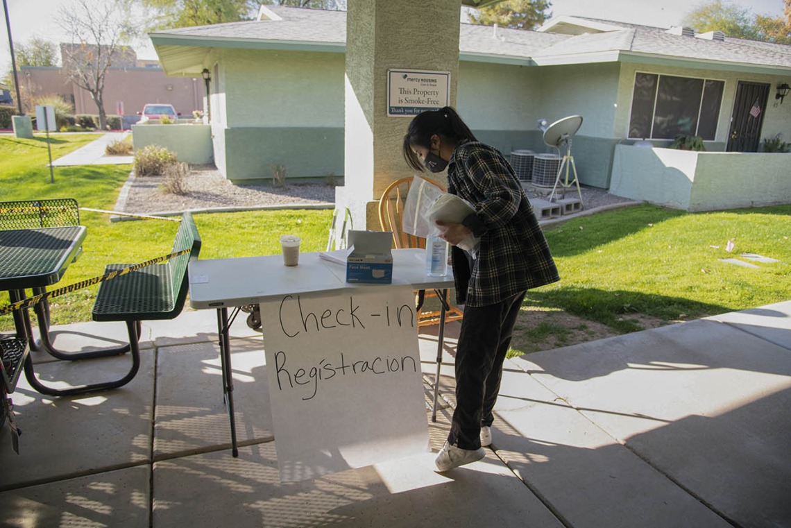Second-year College of Pharmacy student Lisa Wan helps set up the check-in table in the courtyard of El Mirage Senior Village in El Mirage, Arizona.